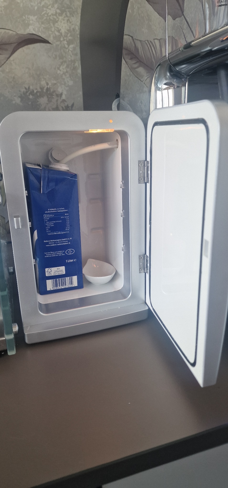 Dometic Mini-Kühlschrank für Milch – geöffnet neben der Kaffeemaschine